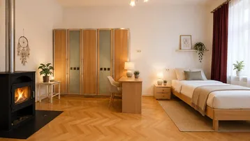 Gemütliches Schlafzimmer mit Kaminofen, Fischgrätparkett und großem Kleiderschrank.