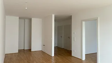 Heller, leerer Raum mit Parkettboden und weißen Wänden, bereit zur individuellen Gestaltung.