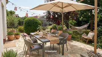 Gemütliche Terrasse mit Essbereich, Sonnenschirm und Hängematte im grünen Garten.