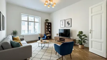 Helles Wohnzimmer mit elegantem Fischgrätparkett, großen Fenstern und moderner Einrichtung.