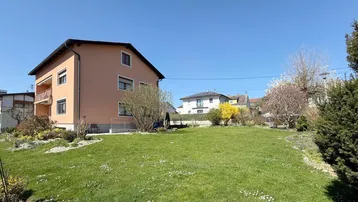 Großer, gepflegter Gartenbereich mit Rasenfläche und Blick auf das Wohnhaus.