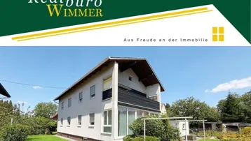 Freistehendes Einfamilienhaus mit Satteldach und großem Gartenbereich unter blauem Himmel.