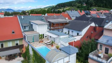Luftaufnahme des Anwesens mit Pool auf der Terrasse und Bergblick im Hintergrund.