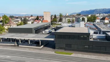 Luftaufnahme eines modernen Gewerbekomplexes mit Flachdächern und umliegender Stadtlandschaft.