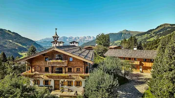 Malerisches Holzchalet in alpiner Landschaft mit beeindruckendem Bergblick und weitläufigem Grundstück.
