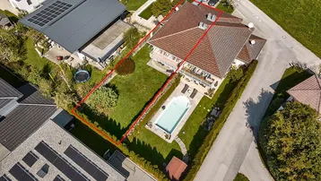 Luftaufnahme eines Hauses mit großem Garten, Pool und umliegender Wohnbebauung.
