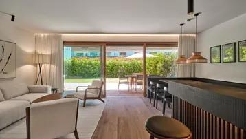 Heller Wohnbereich mit Holzboden, moderner Einrichtung und direktem Zugang zur Terrasse und zum Garten.