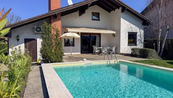 Charmantes Einfamilienhaus mit privatem Pool und sonniger Terrasse im Gartenbereich.