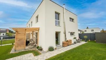 Modernes Einfamilienhaus mit gepflegtem Garten, Terrasse und Holzpergola für entspannte Stunden im Freien.