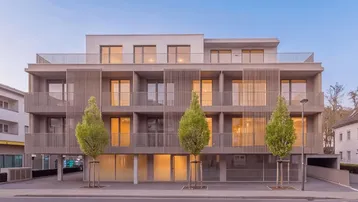 Moderne Architektur eines Mehrfamilienhauses mit zahlreichen Balkonen und großen Fenstern.