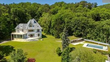 Luftaufnahme der Villa mit großem Garten, Pool und umgebendem Wald.