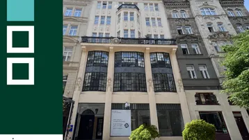 Fassade eines historischen Gebäudes mit großen Fenstern und einem Immobilienlogo im Vordergrund.