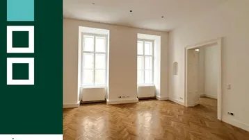 Helles Zimmer mit Fischgrätparkett und hohen Fenstern, bereit zur individuellen Gestaltung.