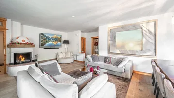 Geräumiger Wohn- und Essbereich mit Kamin, bequemen Sofas und Holzboden.