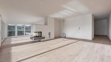 Helles Wohnzimmer mit modernem Kamin, Holzboden und großen Fenstern mit Bergblick.
