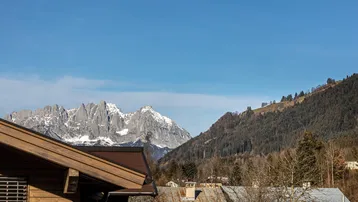 Panoramablick auf die majestätischen schneebedeckten Berge und die umliegende grüne Landschaft.