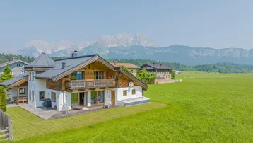 Charmantes Landhaus mit traditioneller Holzfassade, großem Garten und beeindruckendem Bergblick.