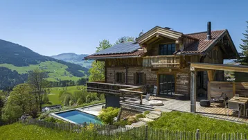 Traditionelles Holzchalet mit Pool, großer Holzterrasse und atemberaubendem Bergblick in sonniger Lage.
