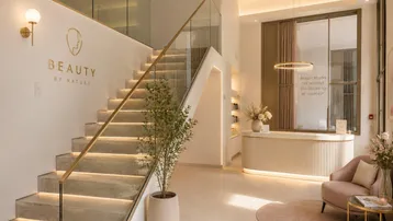 Heller und eleganter Eingangsbereich mit moderner Treppe, Glasgeländer und stilvoller Einrichtung.