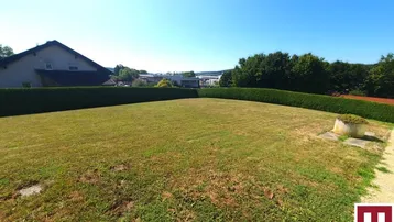 Weitläufiger Rasenbereich mit hoher Hecke und Blick in die Ferne.