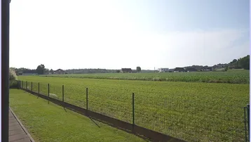 Weitläufiger Blick von der Immobilie auf die angrenzenden grünen Felder und die ländliche Umgebung.