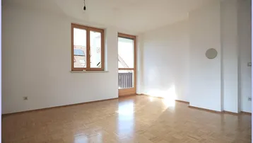 Geräumiges, helles Zimmer mit Parkettboden und großen Fenstern, bereit zur individuellen Gestaltung.