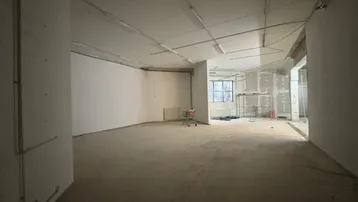 Großer, unfertiger Gewerberaum mit Betonboden und sichtbaren Installationen, bereit für den Ausbau.