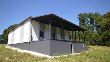 Neues Einfamilienhaus mit überdachter Terrasse und Blick ins Grüne in ländlicher Umgebung.