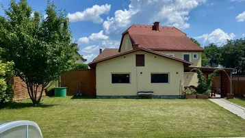 Großer Garten mit gepflegtem Rasen und einem erfrischenden Swimmingpool unter blauem Himmel.