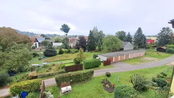 Weitläufiger Blick über Gärten, Bäume und Garagen in einer ruhigen Wohngegend.