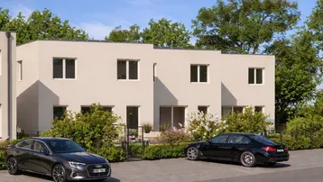 Moderne Reihenhäuser mit hellen Fassaden und privaten Parkplätzen vor dem Gebäude.