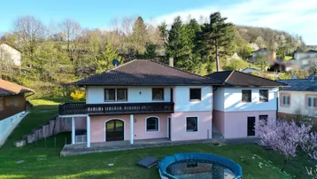Großzügiges Einfamilienhaus mit Garten, Balkon und einem Aufstellpool in ländlicher Umgebung.