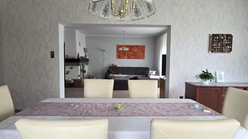Offener Essbereich mit Übergang zum gemütlichen Wohnzimmer, ausgestattet mit Kamin.
