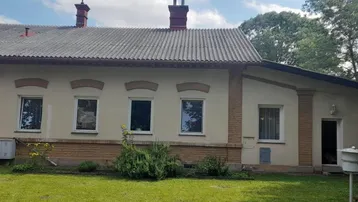 Ansicht der Hausfassade mit mehreren Fenstern und einem traditionellen Satteldach.