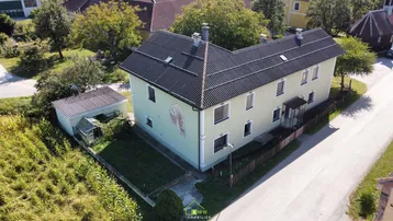Luftaufnahme des ländlichen Hauses mit Satteldach und umliegender Natur.