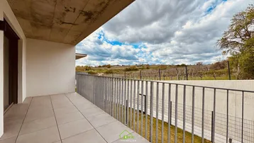Geräumiger Balkon mit Fliesenboden und weitem Blick über die Weinberge und die umliegende Landschaft.