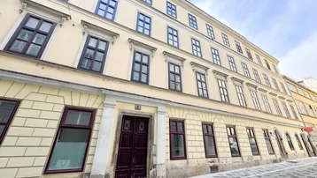 Historische Fassade eines Altbaus mit vielen Fenstern und klassischer Architektur.