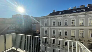 Heller Balkon mit Blick auf die Stadt und die umliegenden Gebäude an einem sonnigen Tag.