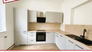 Moderne Küche mit hellgrauen Schränken, Holzarbeitsplatte und integrierten Geräten in einer hellen Wohnung.