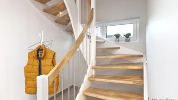 Helle Holztreppe mit weißem Geländer und Fenster im Treppenhaus, modern gestaltet.