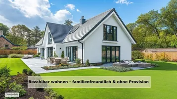 Modernes weißes Einfamilienhaus mit großem Garten und möblierter Terrasse unter blauem Himmel.