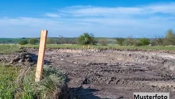 Baugrundstück mit vorbereiteter Fläche für den Bau eines Hauses unter blauem Himmel.