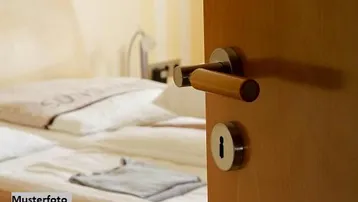 Gemütliches Schlafzimmer mit einem bequemen Bett und einer geöffneten Holztür, die Licht hereinlässt.