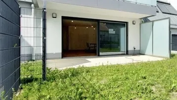 Moderne Wohnanlage mit Terrasse und kleinem Gartenbereich, ideal für entspannte Stunden im Freien.