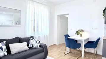 Heller Wohn- und Essbereich mit modernem Sofa, Esstisch und Blick auf die Umgebung.