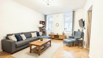 Helles Wohnzimmer mit modernem Sofa, Holztisch und Fischgrätparkettboden, ideal für entspannte Stunden.