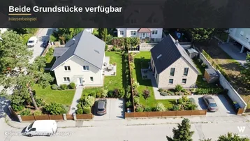 Luftaufnahme zweier moderner Einfamilienhäuser mit gepflegten Gärten und Zufahrten.