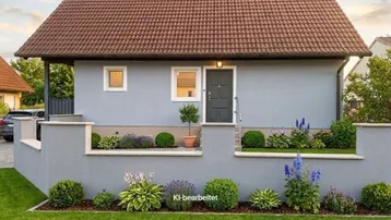 Einfamilienhaus mit gepflegtem Vorgarten und Satteldach unter blauem Himmel.