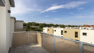 Geräumiger Balkon mit Fliesenboden und Blick auf die umliegende Wohnsiedlung.