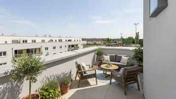 Gemütliche möblierte Terrasse mit Pflanzen und Blick auf die Umgebung, ideal zum Entspannen im Freien.